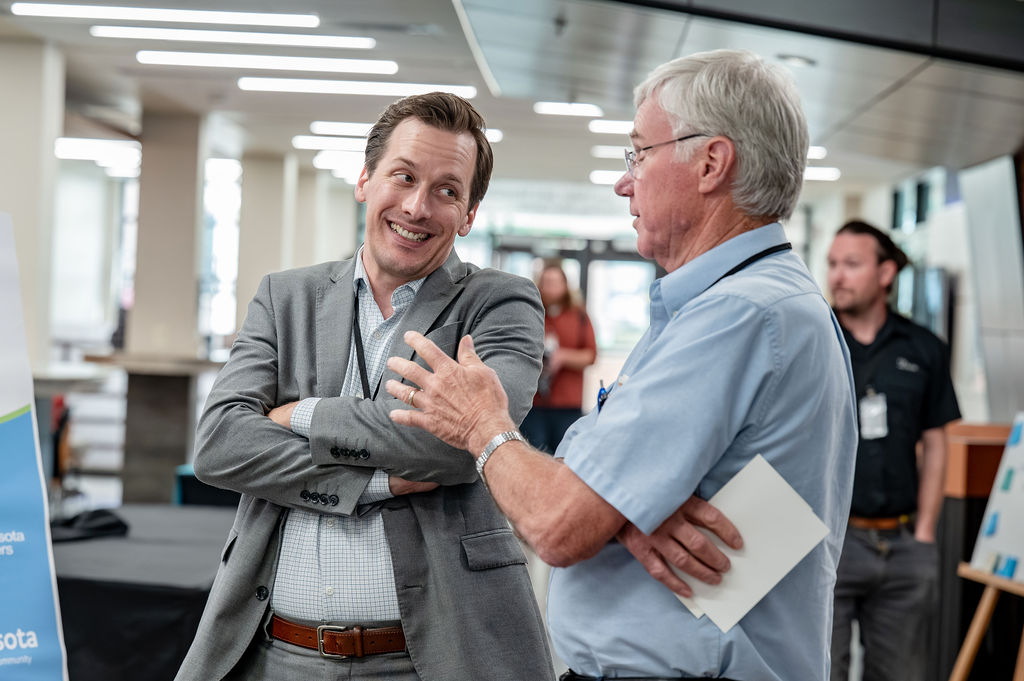 Two Minnesota Cooperative Summit attendees talking during a networking session.